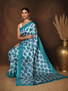 Tonal-blue Kashmiri Silk printed saree with a scattered leaf print in light and deep blue, an intricate scalloped end-panel, and a solid teal border.