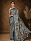 Dark blue and tan printed saree with geometric, leaf-like motifs and a dark blue border, styled with a reference blouse.